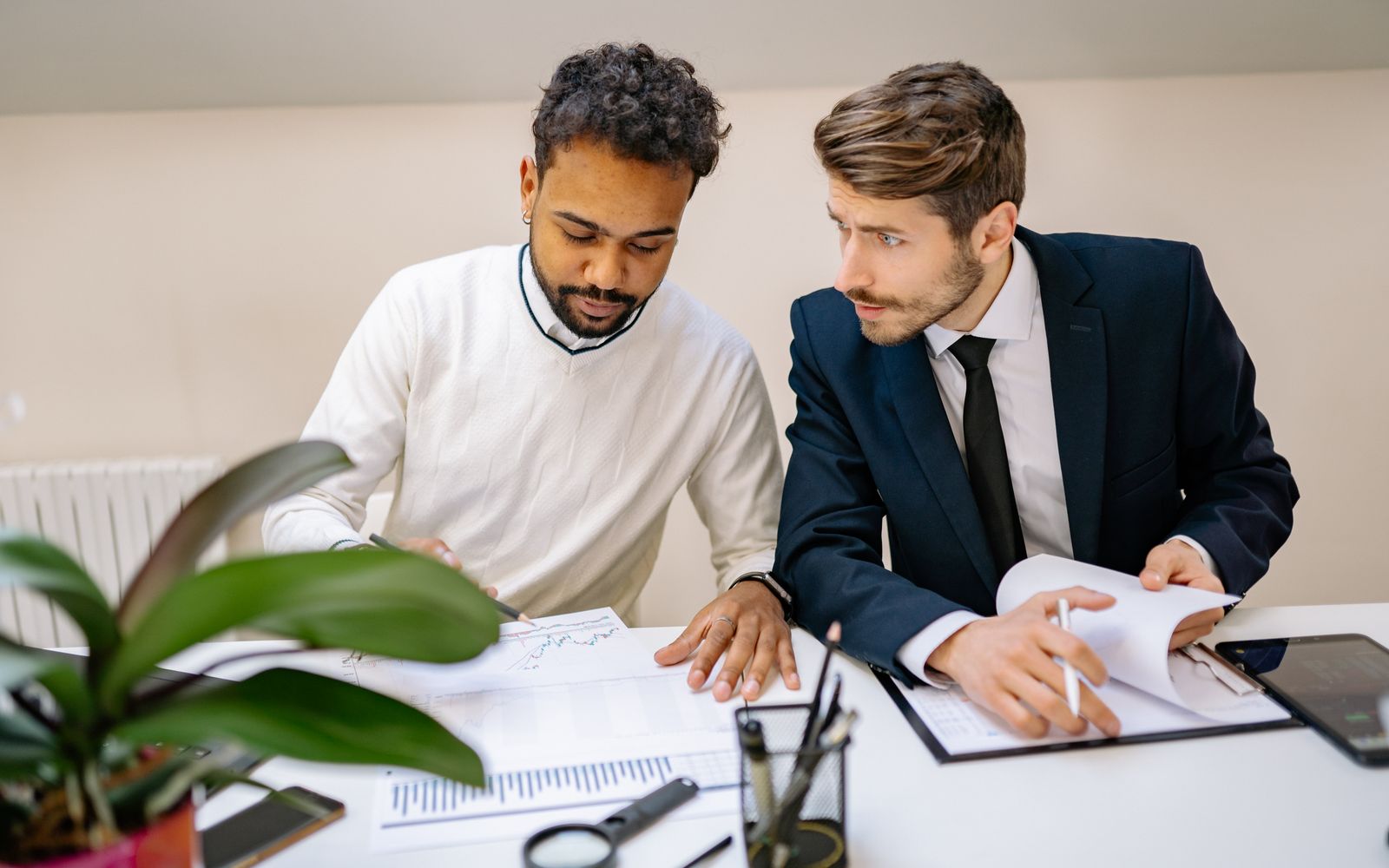 Two colleagues discussing documents in a modern office