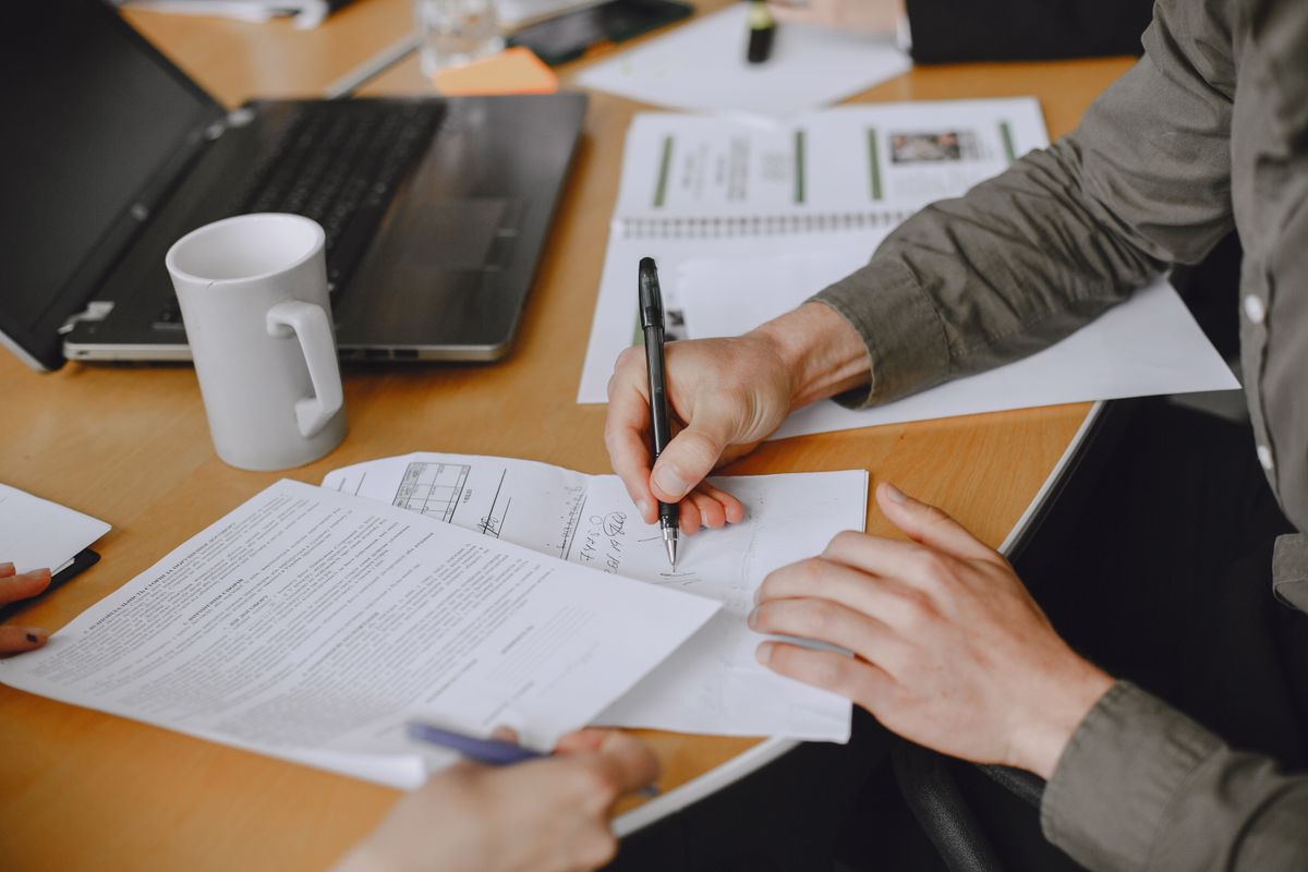 Colleagues signing documents at a business meeting